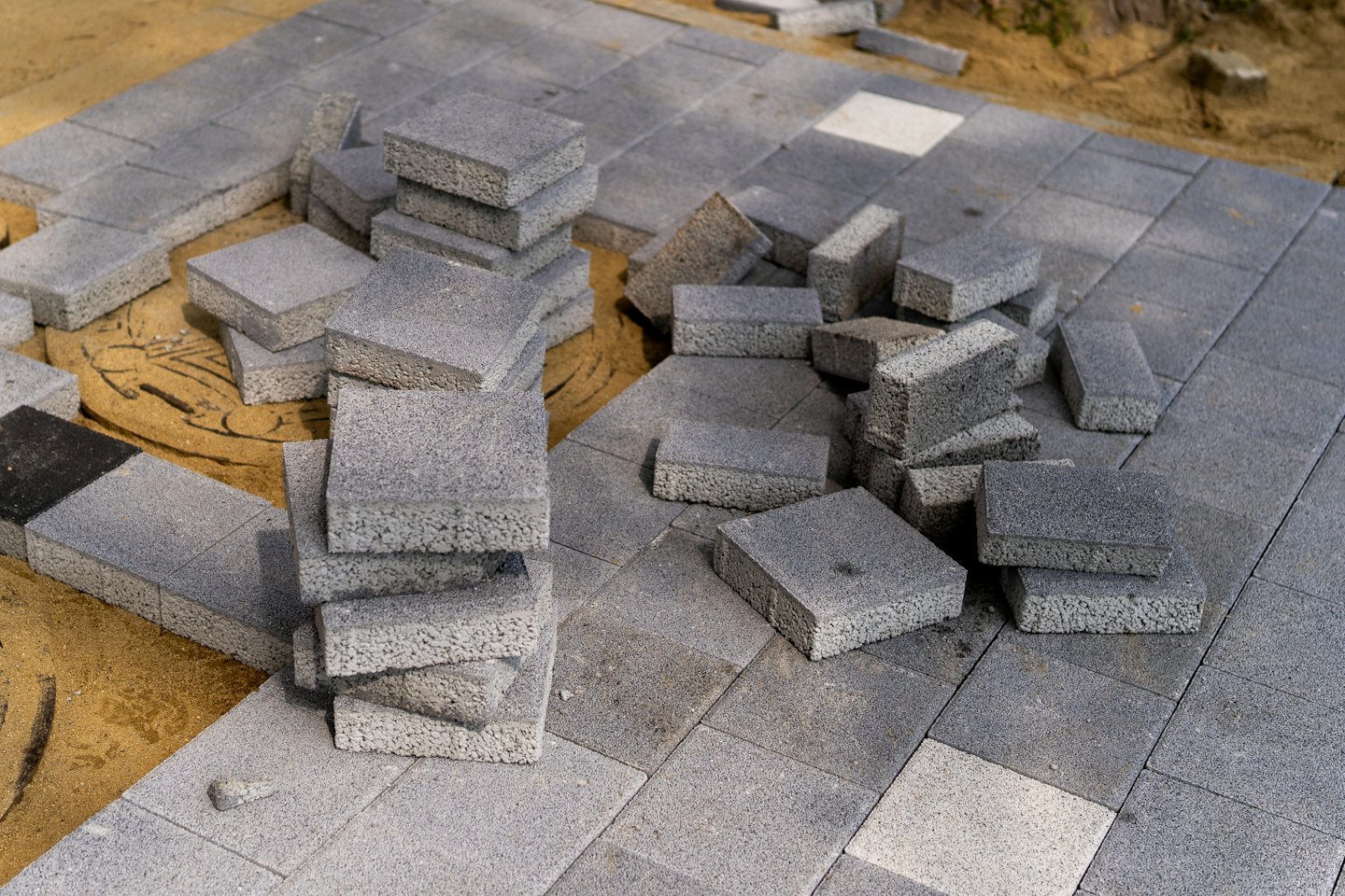 Graue Betonplatten für eine neue Terrasse werden verlegt.